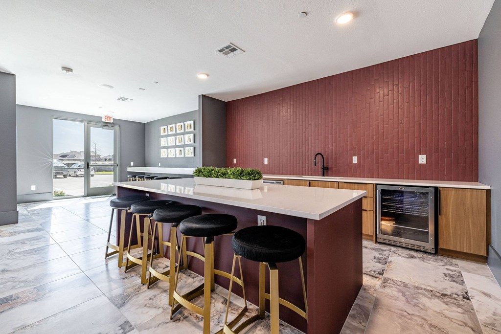 a kitchen with a long island with bar stools and a fireplace