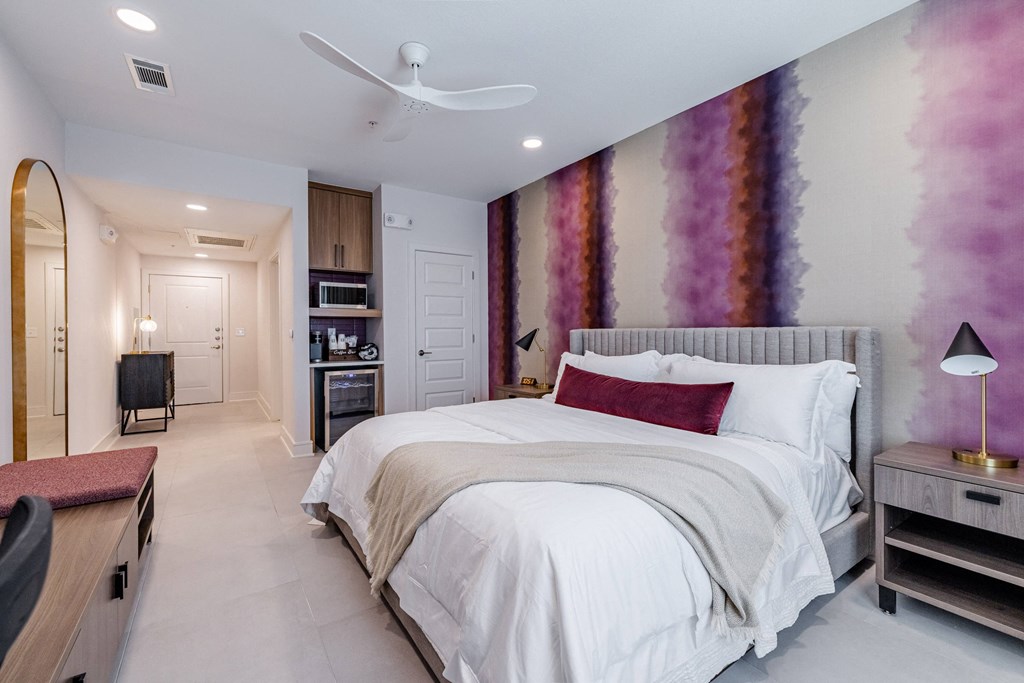 a bedroom with purple and white walls and a white bed