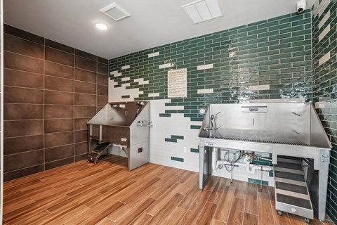 A kitchen with a stainless steel sink and wooden floors.