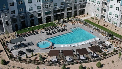 An aerial view of a pool surrounded by lounge chairs and umbrellas.