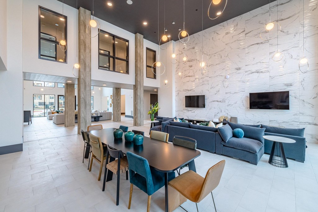 a living room and dining room with blue couches and a table