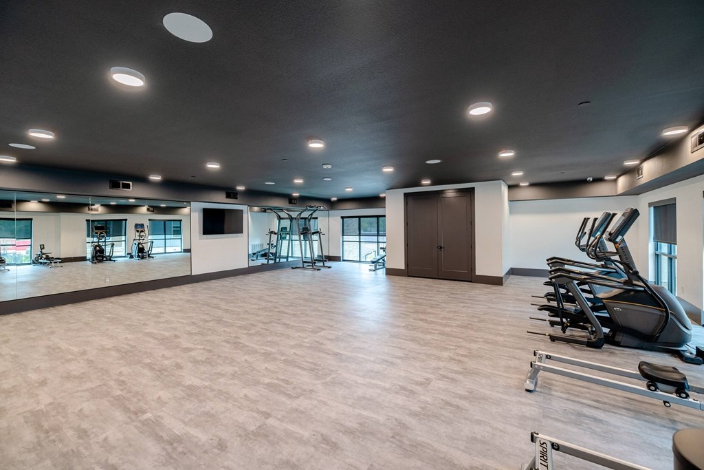 a gym with cardio machines and weights in a large room