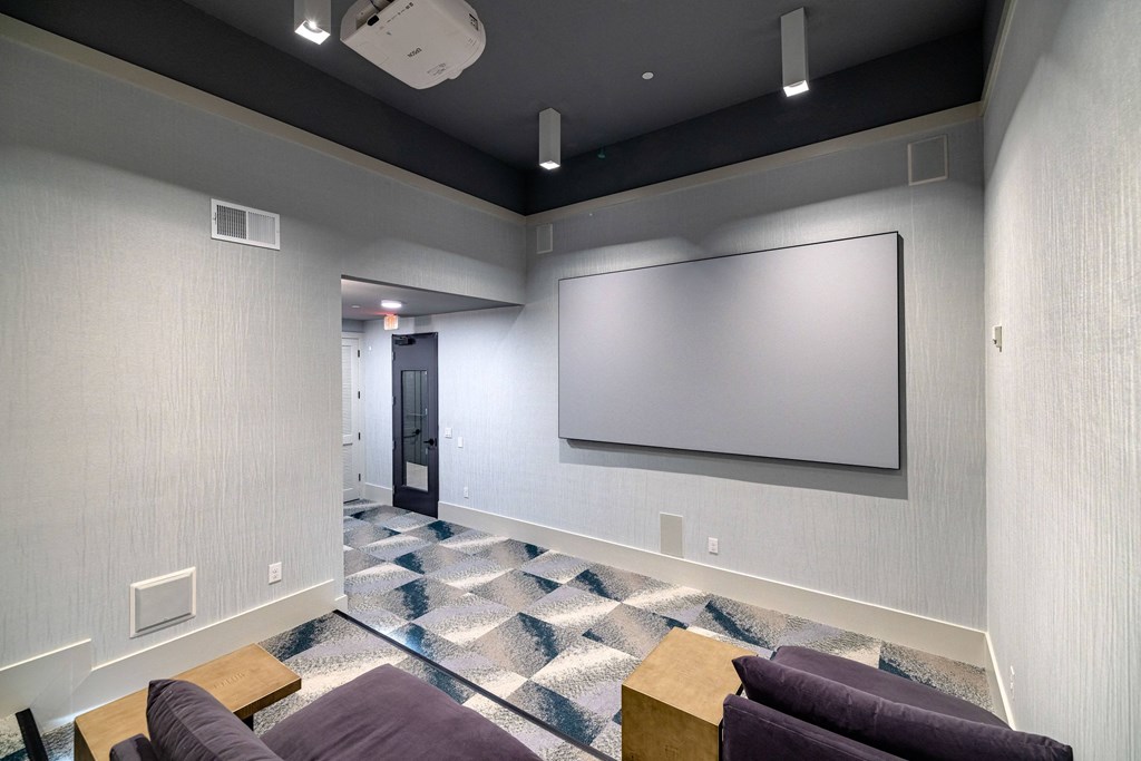 a large room with couches and a screen on the wall