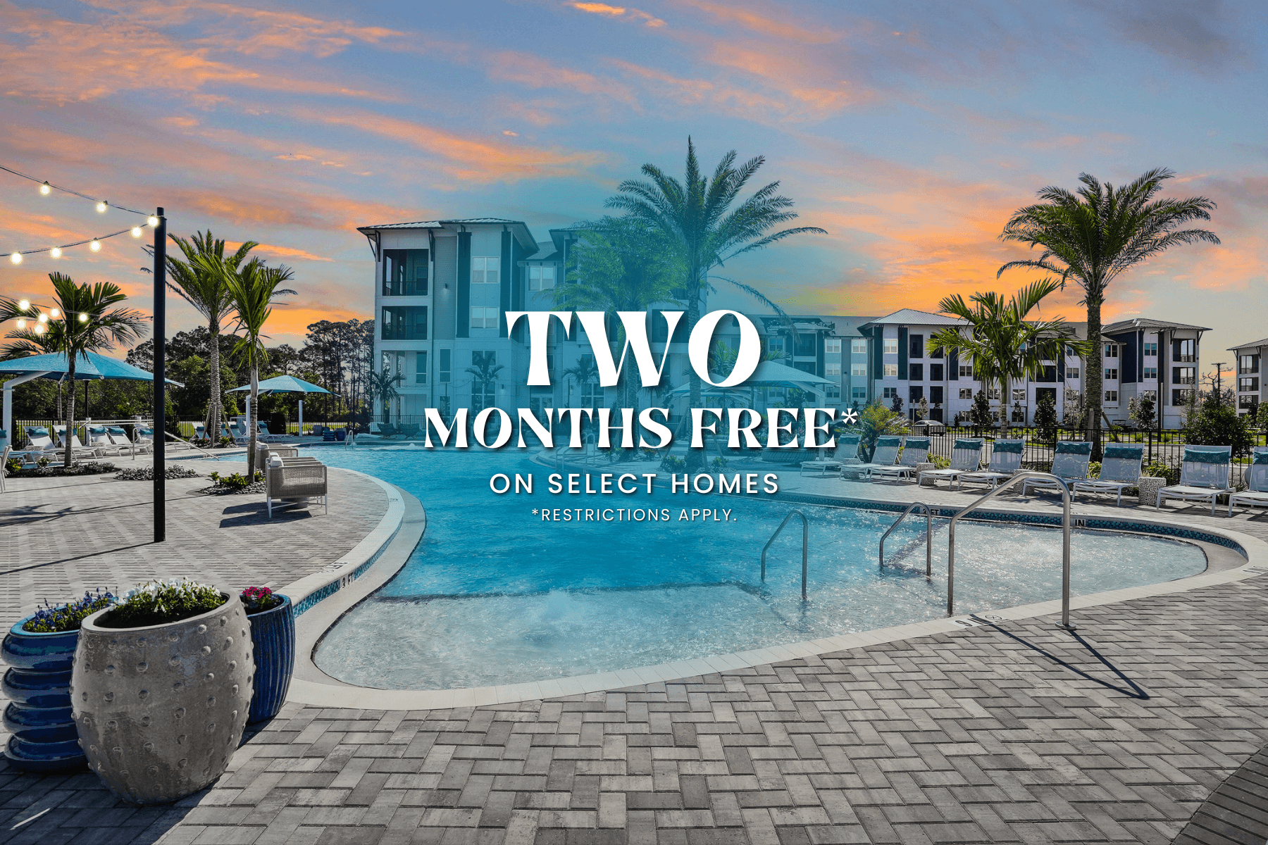 A pool area with a sign that says "TWO MONTHS FREE ON SELECT HOMES" and "RESTRICTIONS APPLY".