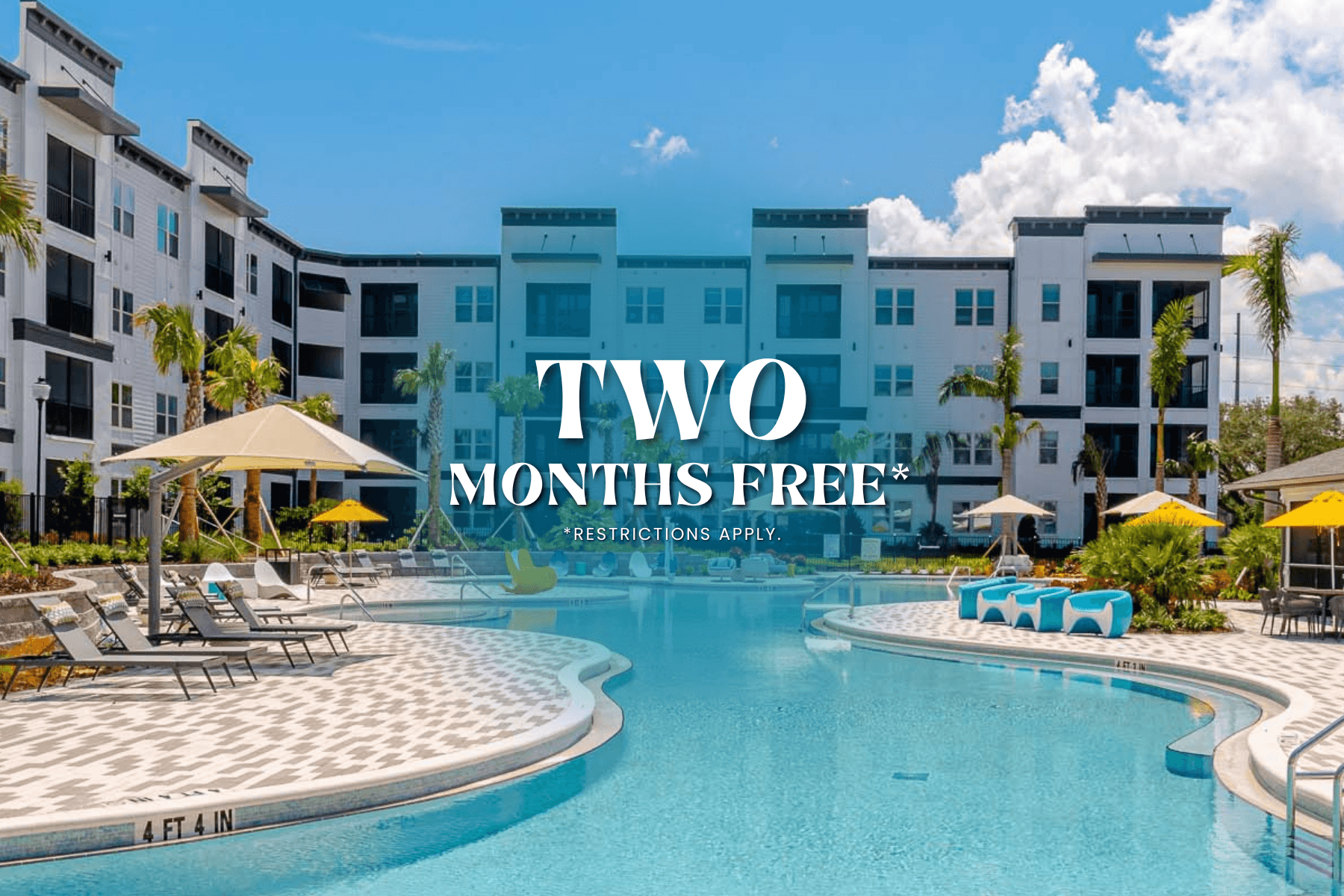 A pool surrounded by chairs and umbrellas with a sign that says "TWO MONTHS FREE".