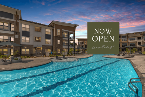 A pool in front of apartment buildings with a sign that says "Now Open".