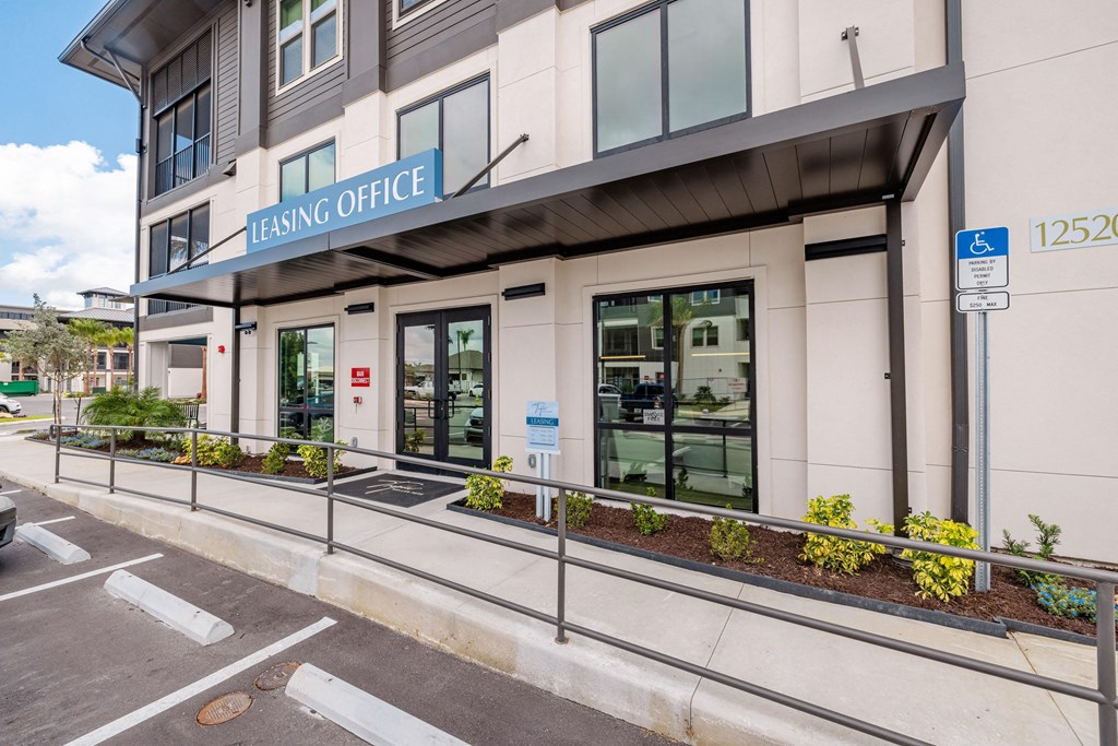 a beige building with a blue sign on the side of a street