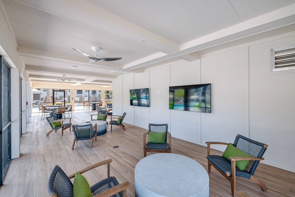 a lounge area with chairs and tables and a television