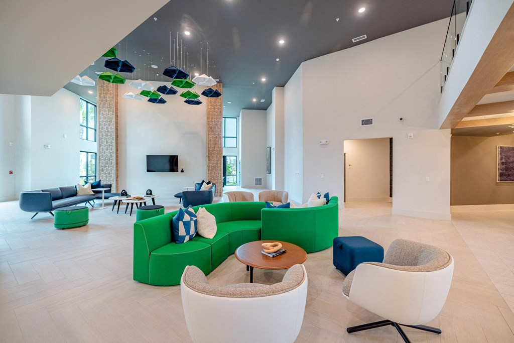 a large lobby with couches and chairs and a tv