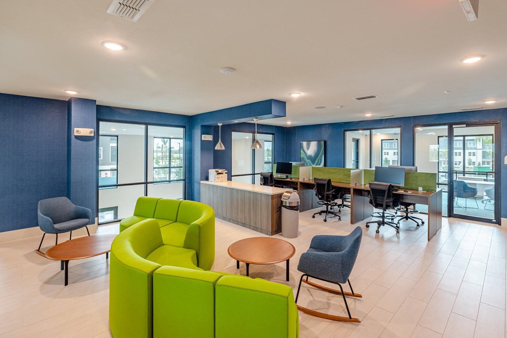 a lounge area with green couches and chairs and a table with chairs