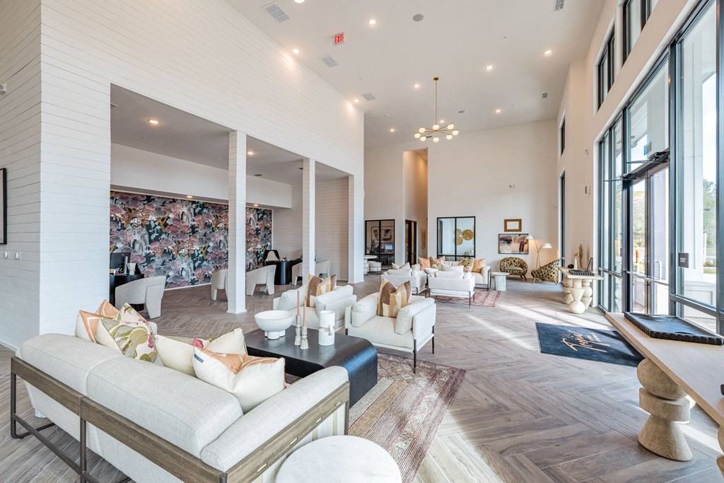 a large living room with couches and chairs and large windows