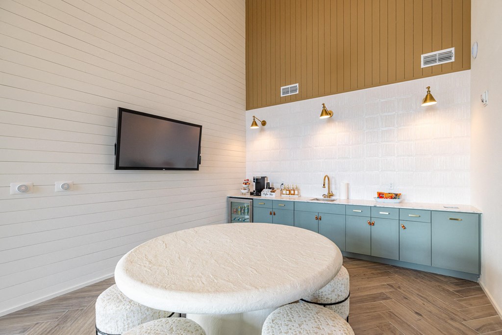 a round table with four stools in a room with a tv