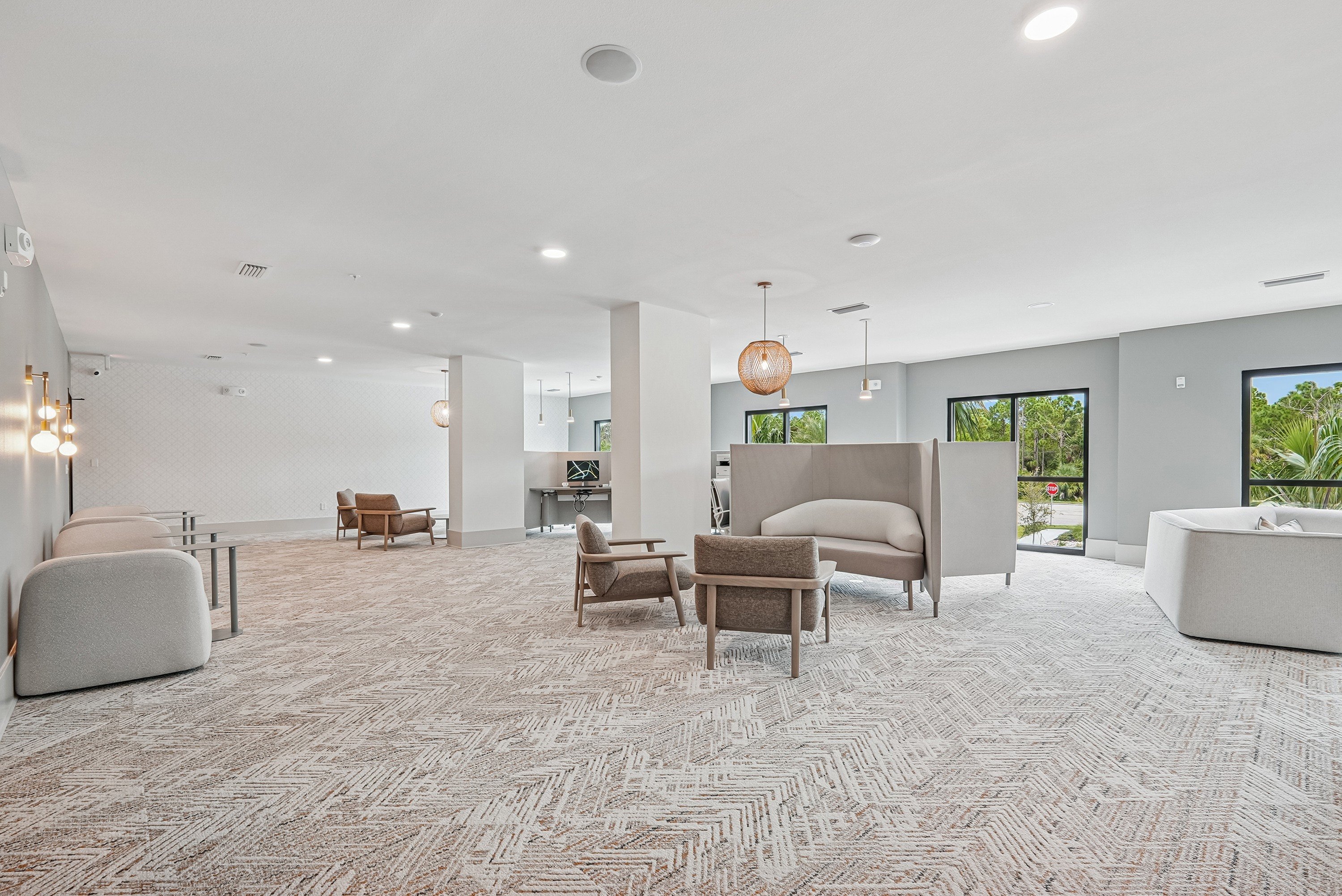 A spacious living room with a patterned carpet and modern furniture.
