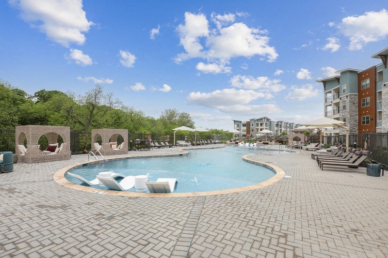 a swimming pool at a hotel with chairs and umbrellas