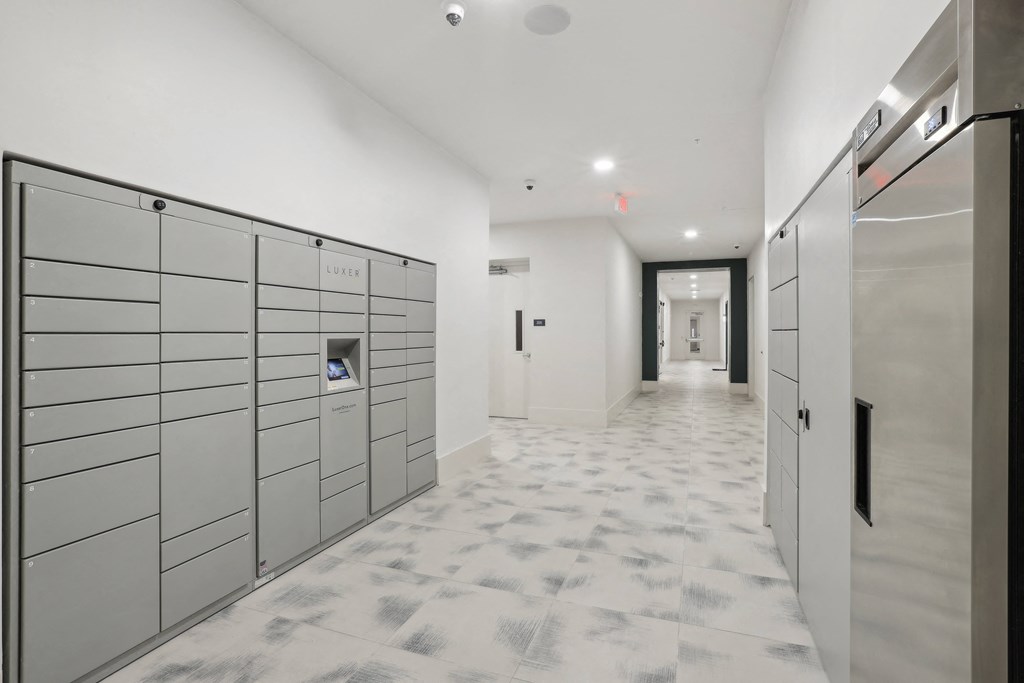 a row of lockers in a white room with a hallway in the background