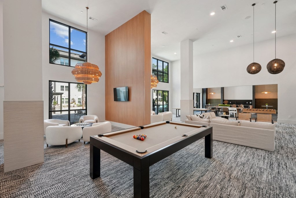 a living room with a pool table and couches