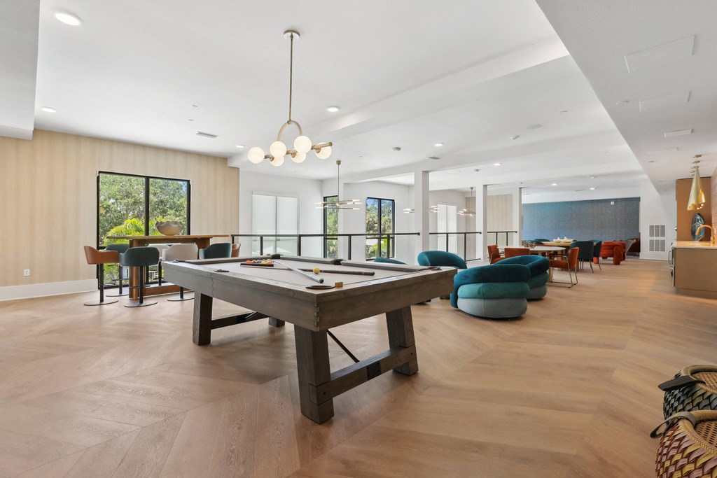 a game room with a pool table in the middle of it