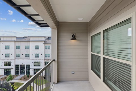 A balcony with a view of a building and trees.