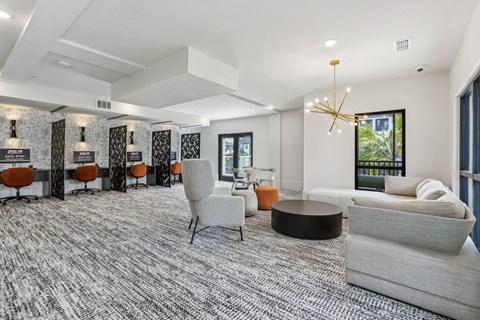 A modern living room with a grey carpet and a large window.