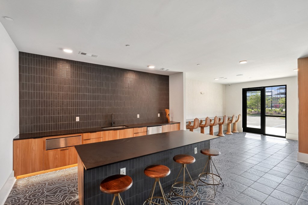 a large kitchen with a long counter and bar stools