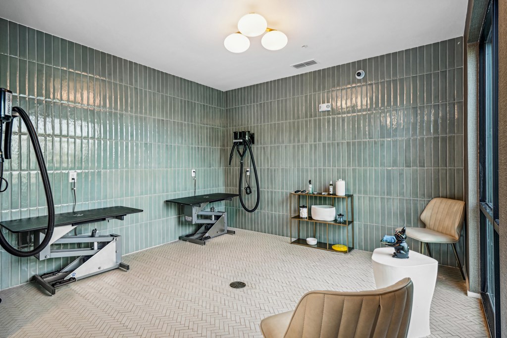 A bathroom with a shower, sink, and chair.