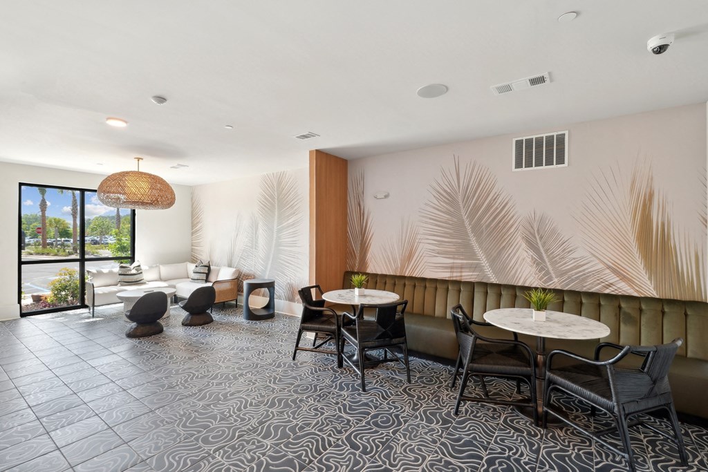 the lobby of a hotel with tables and chairs
