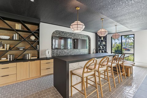 A modern kitchen with wooden chairs and a marble countertop.
