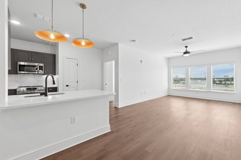 A kitchen with a white countertop and a microwave on it.