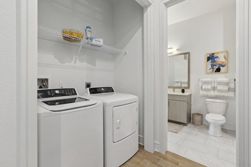 a laundry room with a washer and dryer and a bathroom with a toilet