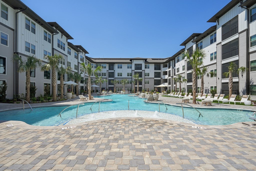 an outdoor pool with an apartment building in the background