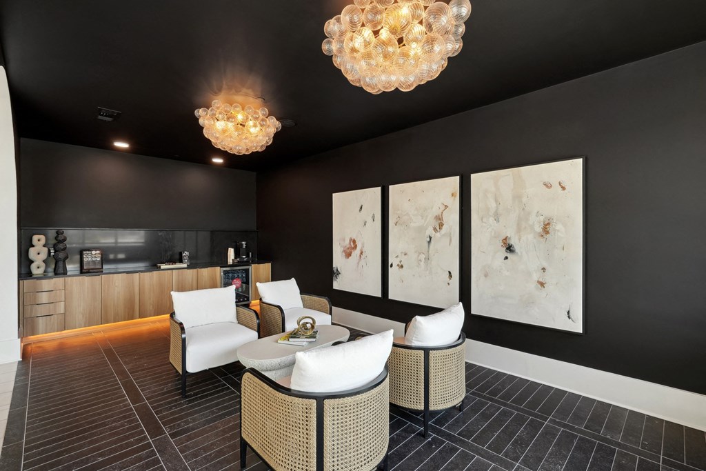 a living room with black walls and white furniture and chandeliers