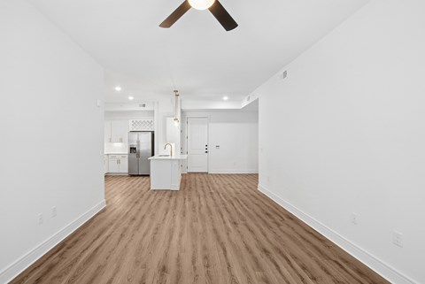 A room with a ceiling fan and wooden flooring.