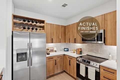 A kitchen with a stainless steel refrigerator and wooden cabinets.