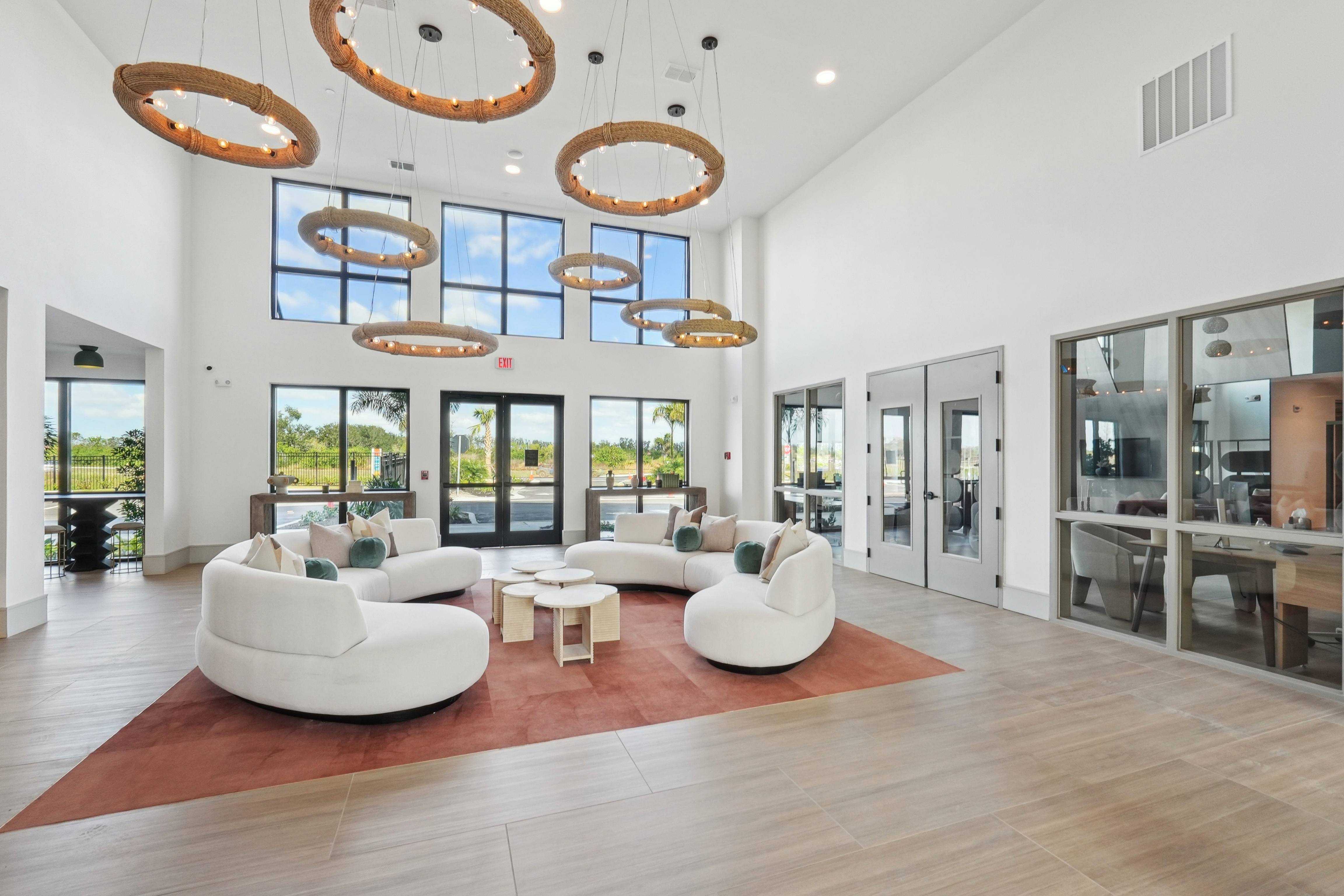 A modern living room with white furniture and a large rug.