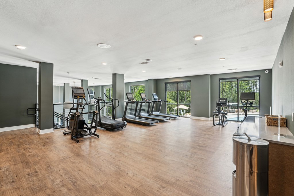 A gym with a variety of equipment including treadmills, weights, and exercise machines.