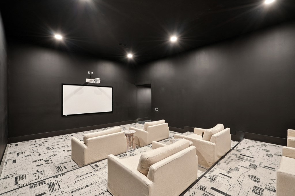 a large screening room with white chairs and a projector screen