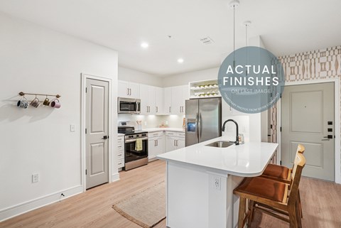 A kitchen with white cabinets and a white island.