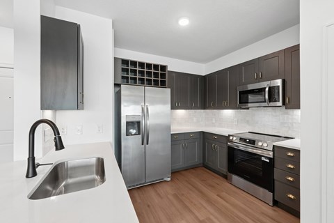 A modern kitchen with a stainless steel refrigerator and oven.