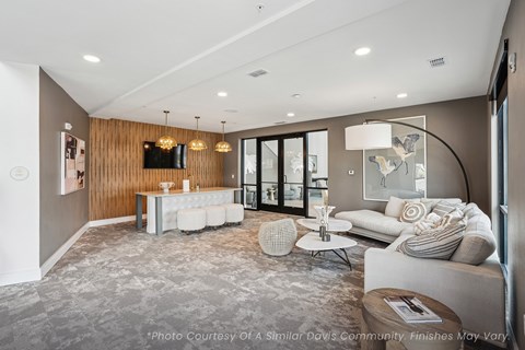 A modern living room with a grey carpet and a wooden wall.