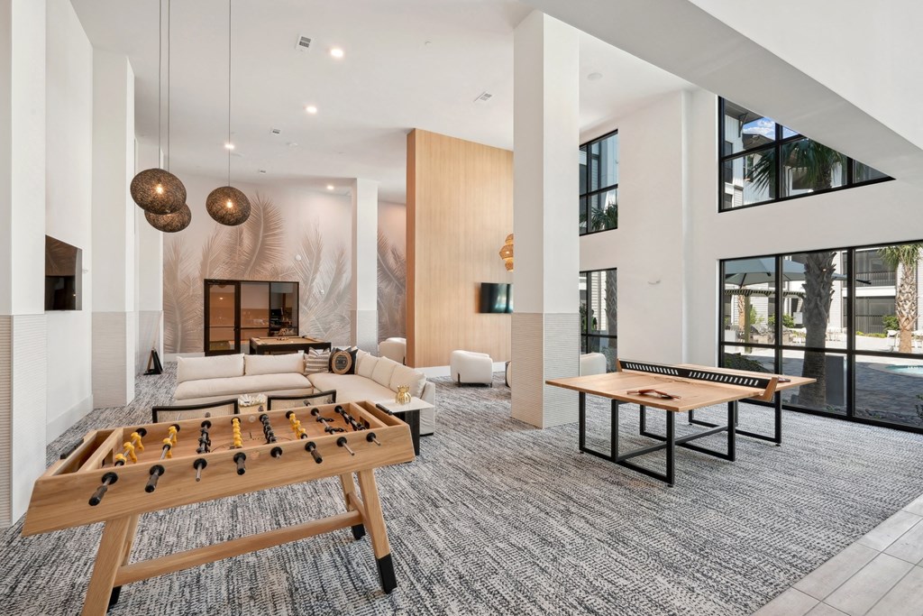 a spacious living room with two foosball tables and a games room