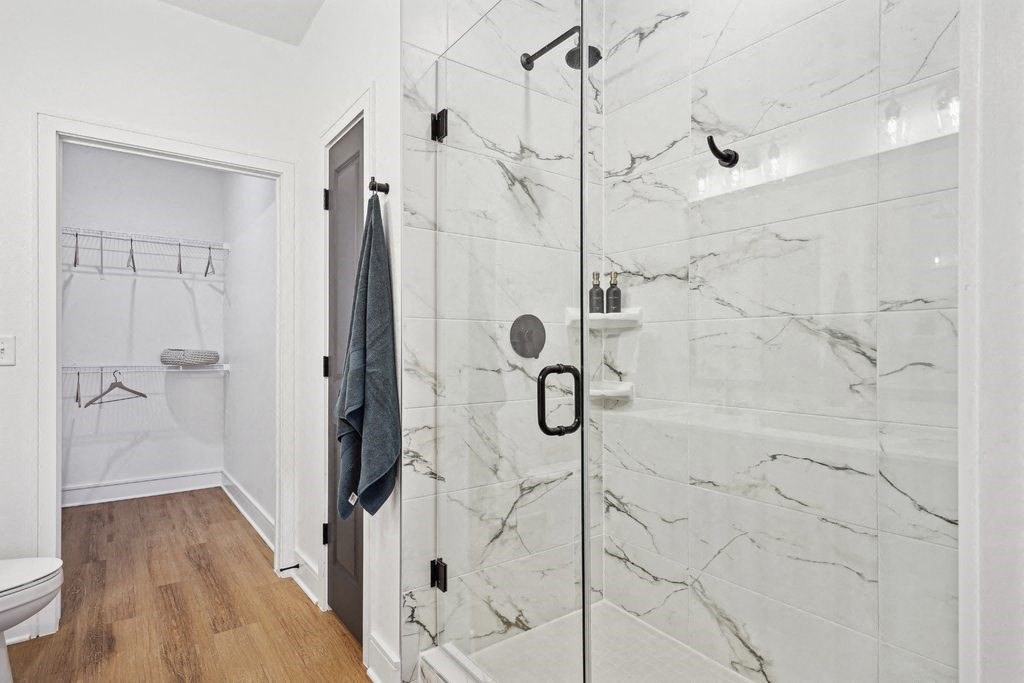 Bathroom with Quartz Countertops, Double Vanity Sinks, Walk-in Shower, and Walk-in Closet
