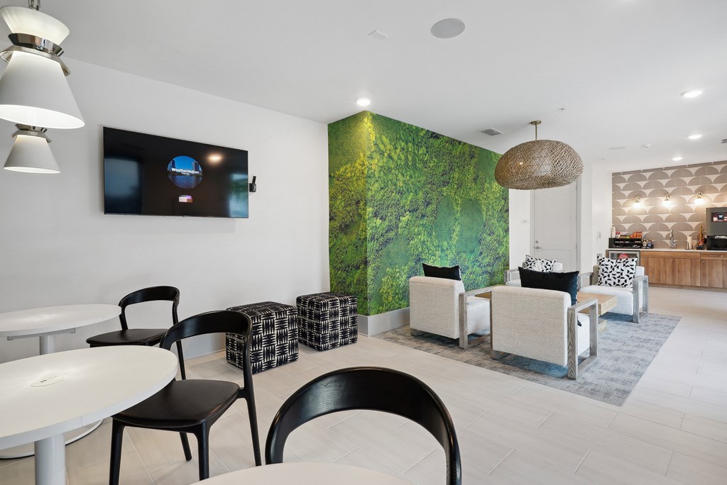 a restaurant with white tables and chairs and a green wall in the corner