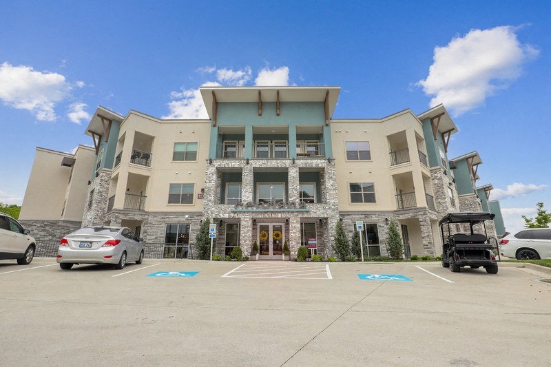 a large building with a parking lot and cars in front of it
