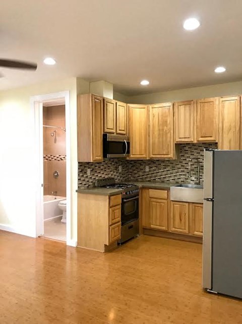 A kitchen with wooden cabinets and a refrigerator.