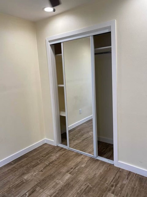 A room with a sliding door and wood flooring.