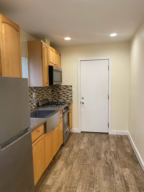 A kitchen with wooden cabinets and a white door.