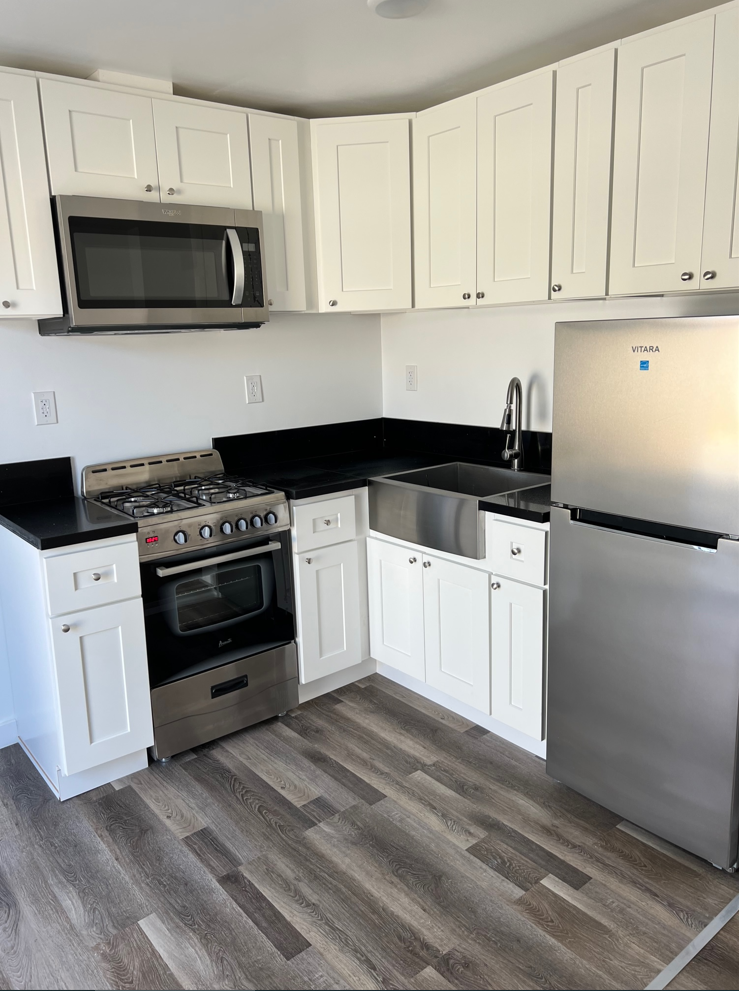 a kitchen with stainless steel appliances and white cabinets