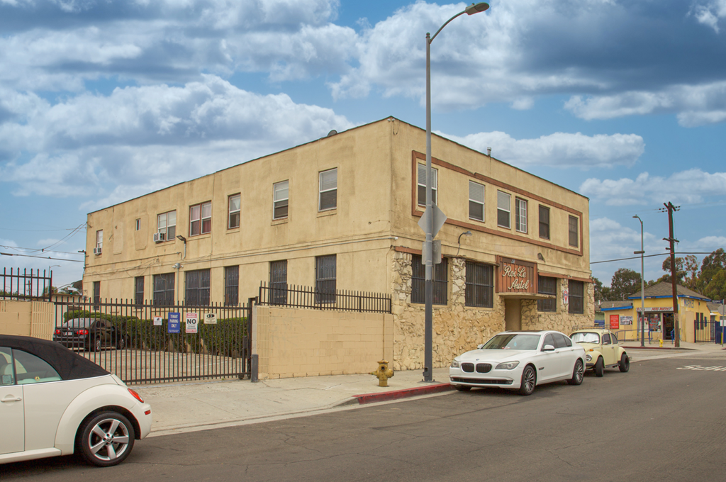 A white car is parked in front of a building with a sign that reads "SALON".