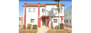 A red and white building with a palm tree in front.