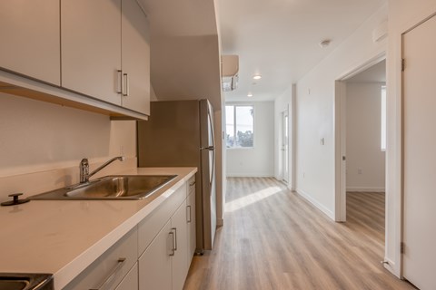 A kitchen with white cabinets and a stainless steel sink.